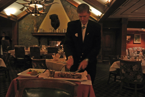 Thomas, a captain at the Ranchers Club cuts a two-bone Kurobuta pork chop