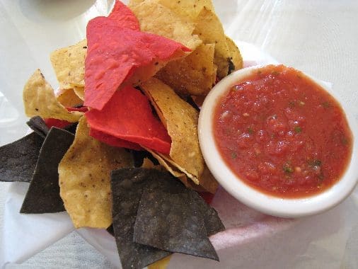 Red, yellow and blue corn chips with salsa