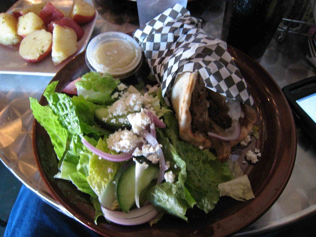 A traditional Greek gyro with a Greek salad and potatoes