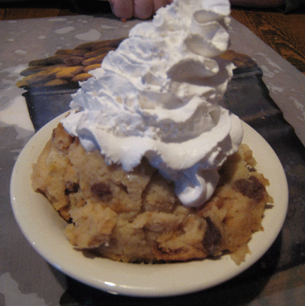Bread pudding topped with a mound of whipped cream