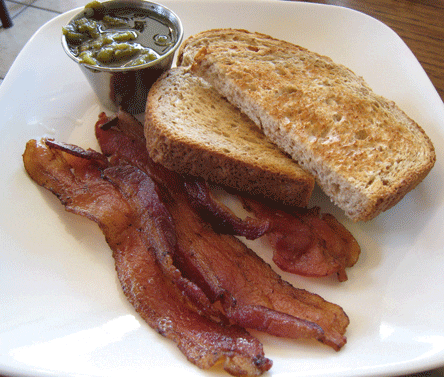 A side of wheat toast, bacon and green chile